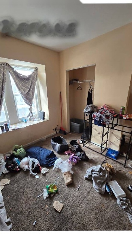 Rowhome bedroom full of trash before cleanout